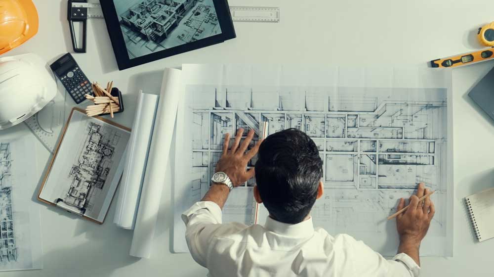 Architect standing over blueprints of a house