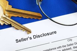 House key next to paper that says Seller's Disclosure
