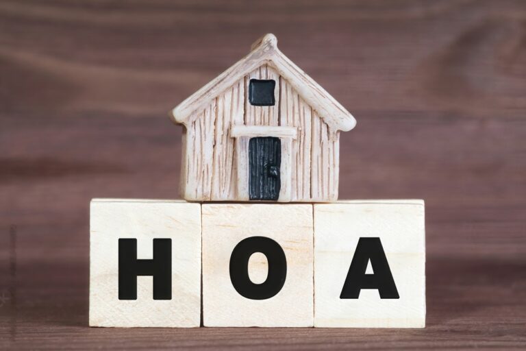 Miniature house on top of wooden blocks reading HOA.
